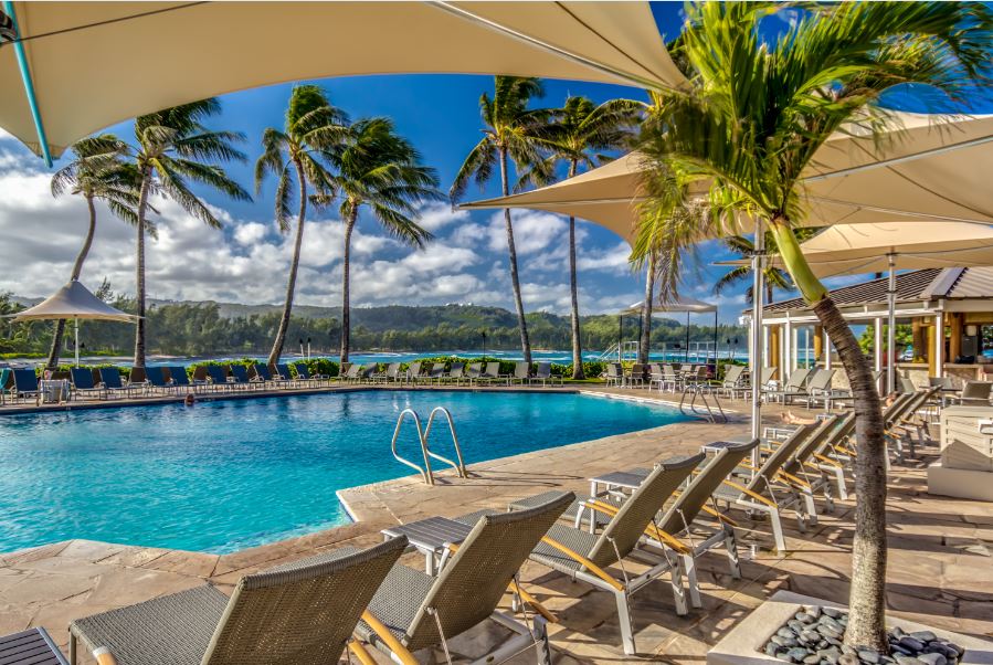 A resort swimming pool surrounded by cabana chairs