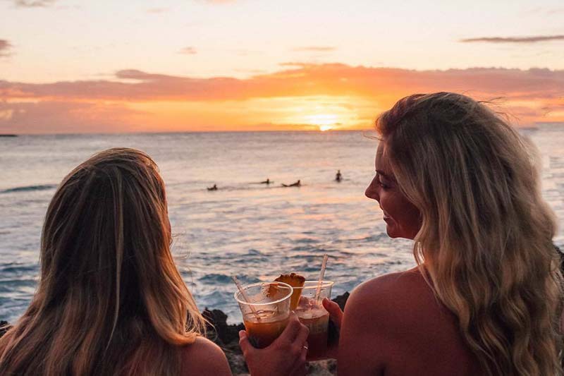 Two women watching the sunset from the beach