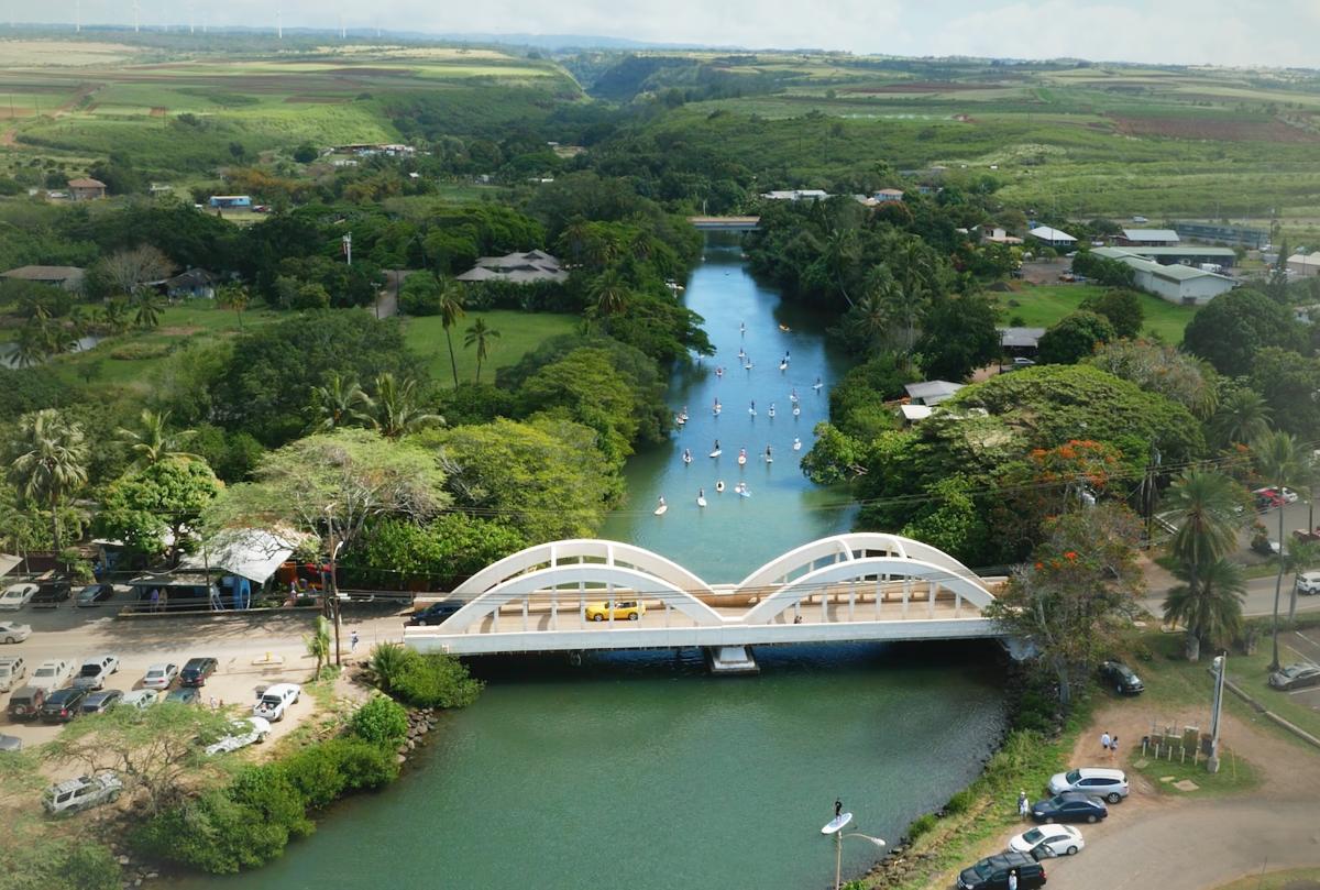 Stand up paddle boarders riding down the Anahulu River, Oahu