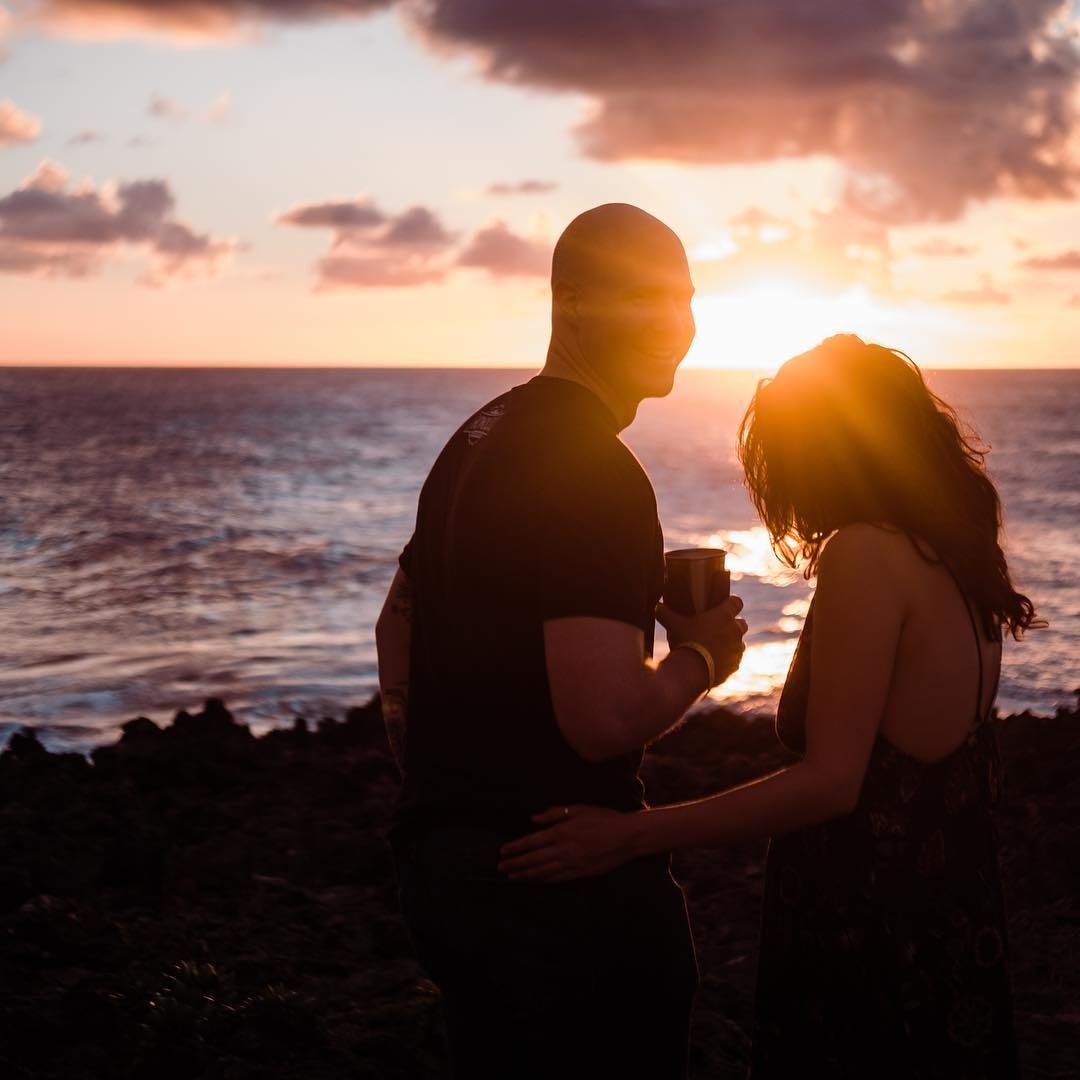 A silhouette of a couple on the beach at sunset