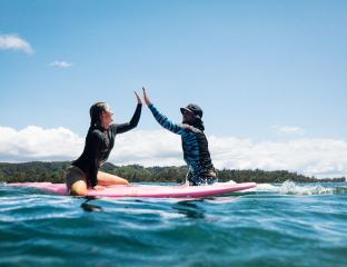 Surfers high five