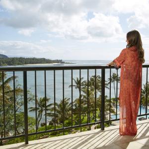 Woman standing on a balcony overlooking the ocean