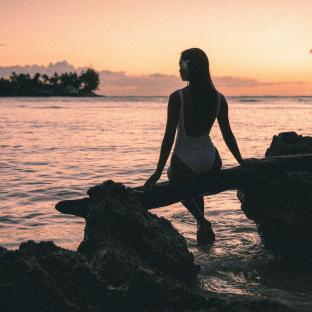 woman on tree kawela bay sunset